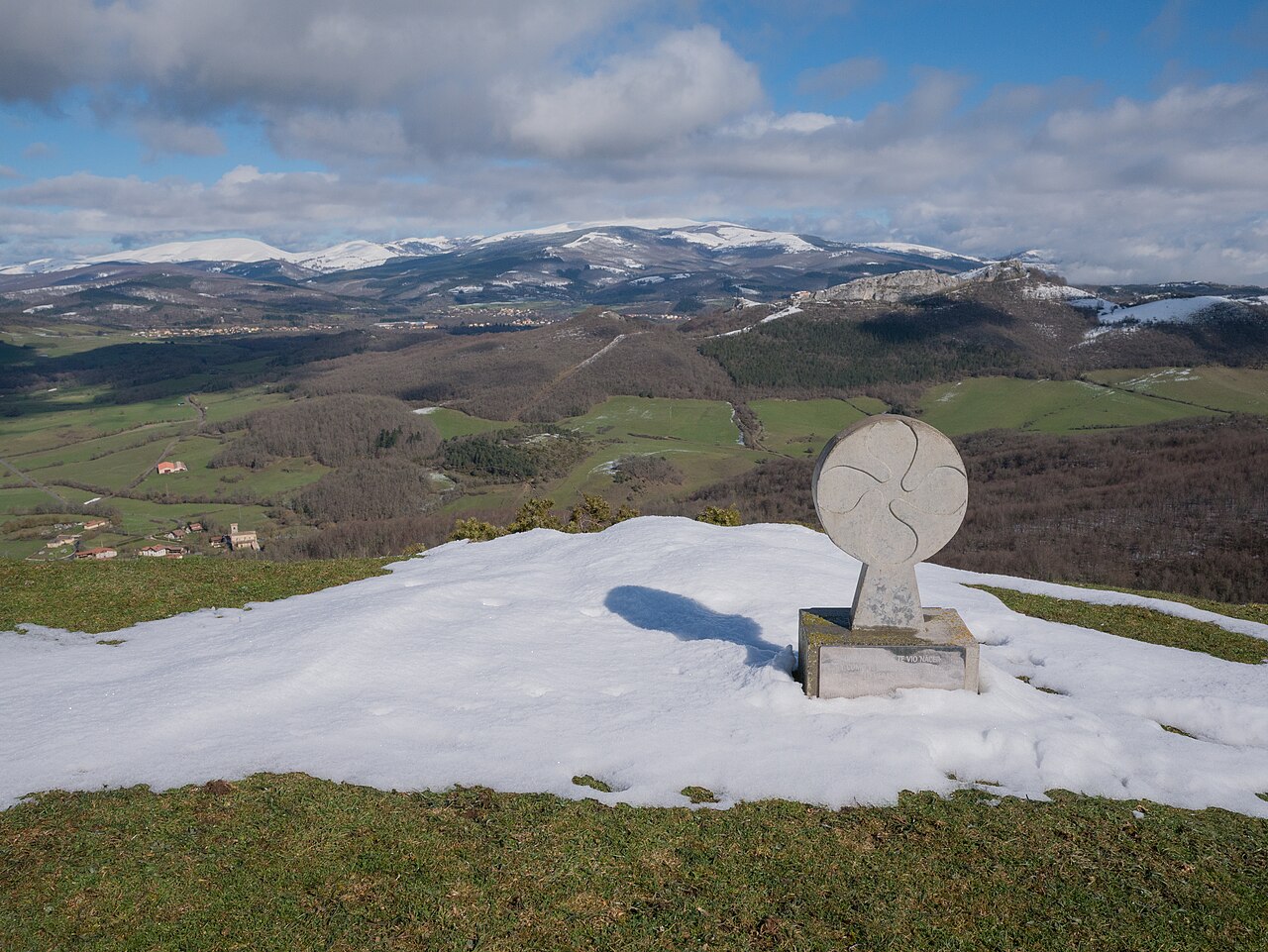 Stele showing a Basque cross on the Ganalto summit. Gorbeia mountain range in the background. Badaia mountain range, Álava, Basque Country, Spain