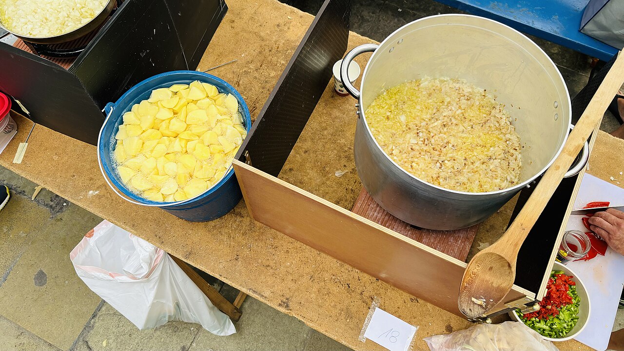 Preparación de marmitako, pelando patatas y pochando la cebolla