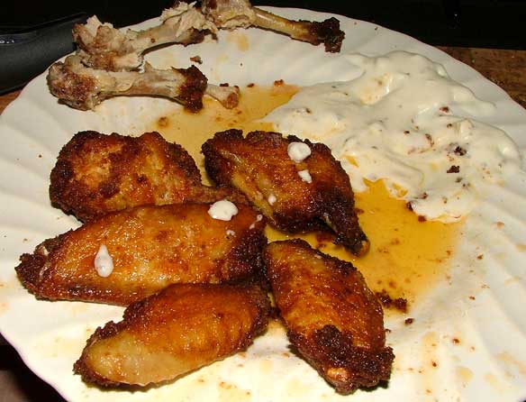Homemade Buffalo Wings, coated in Italian bread crumbs, deep fried, with butter, vinegar, and Tabasco hot sauce and chunky bleu cheese dressing dipping sauce.