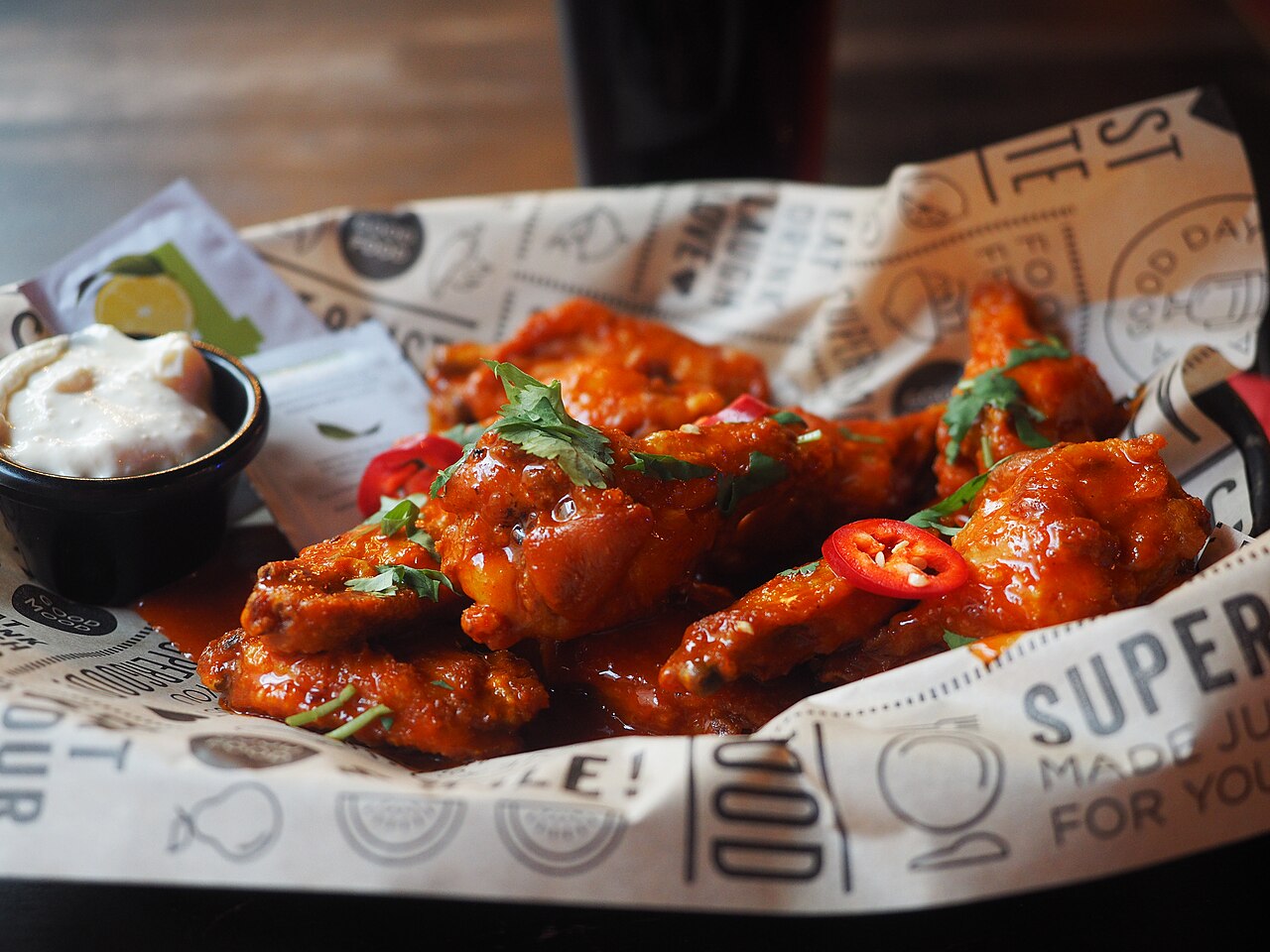 A plate of 10 chicken wings with "Hot as Fuck" sauce, served at restaurant Bar Loosister in Sörnäinen, Helsinki, Finland.