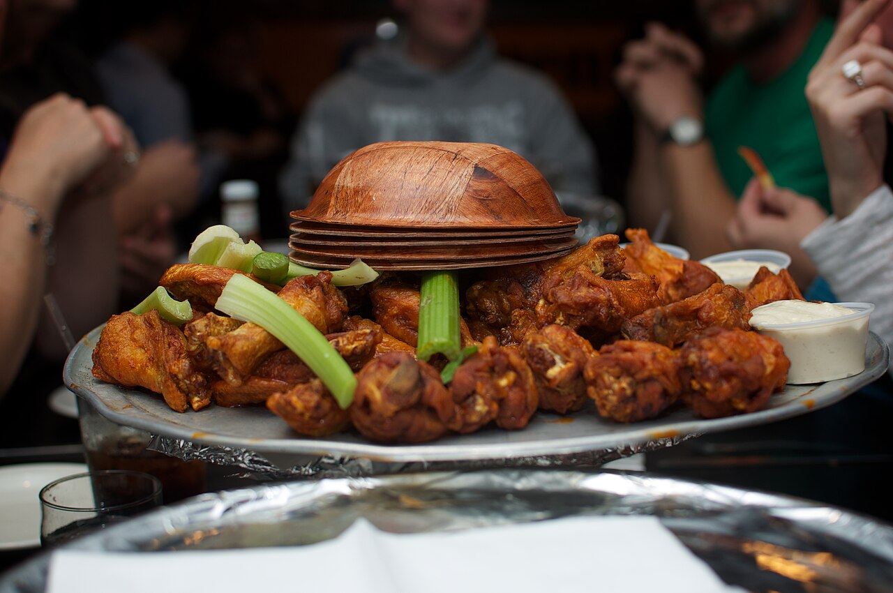 A bowl of chicken (Buffalo) wings and celery.