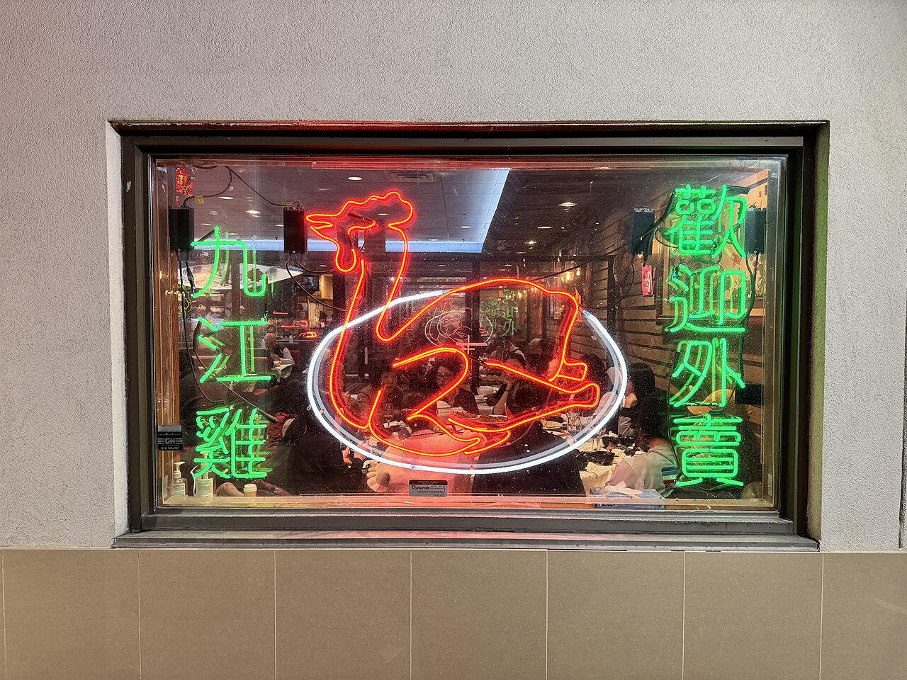 Under the glow of a 'Welcome' and chicken neon sign, New Kennedy Square in Markham, Ontario, comes alive, captured on the evening of March 23, 2025