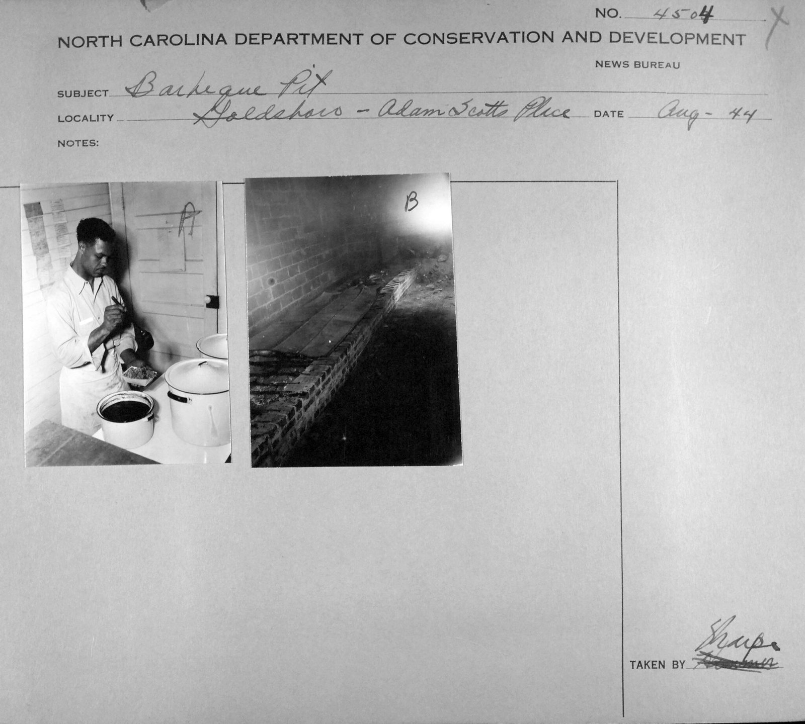 A state News Bureau photo sheet headed Barbeque Pit, locality Goldsboro, Adam Scotts Place, dated Aug-44 in pencil. Two prints are mounted on it. One shows a man in a white shirt and apron at a table with two tall enamel stockpots and a pan of chopped meat, working with a short-handled tool; notices are tacked to the plank wall behind him. The other looks along the inside of a long brick pit, ash on the floor between brick walls and iron bars laid across.