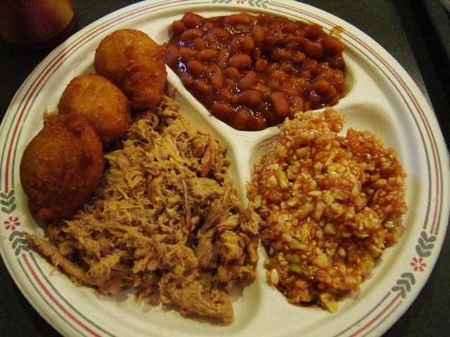 Lexington style North Carolina barbecue served with hushpuppies, baked beans and red cole slaw. Lexington style North Carolina barbecue uses a vinegar and ketchup type sauce, and uses only the pork sh