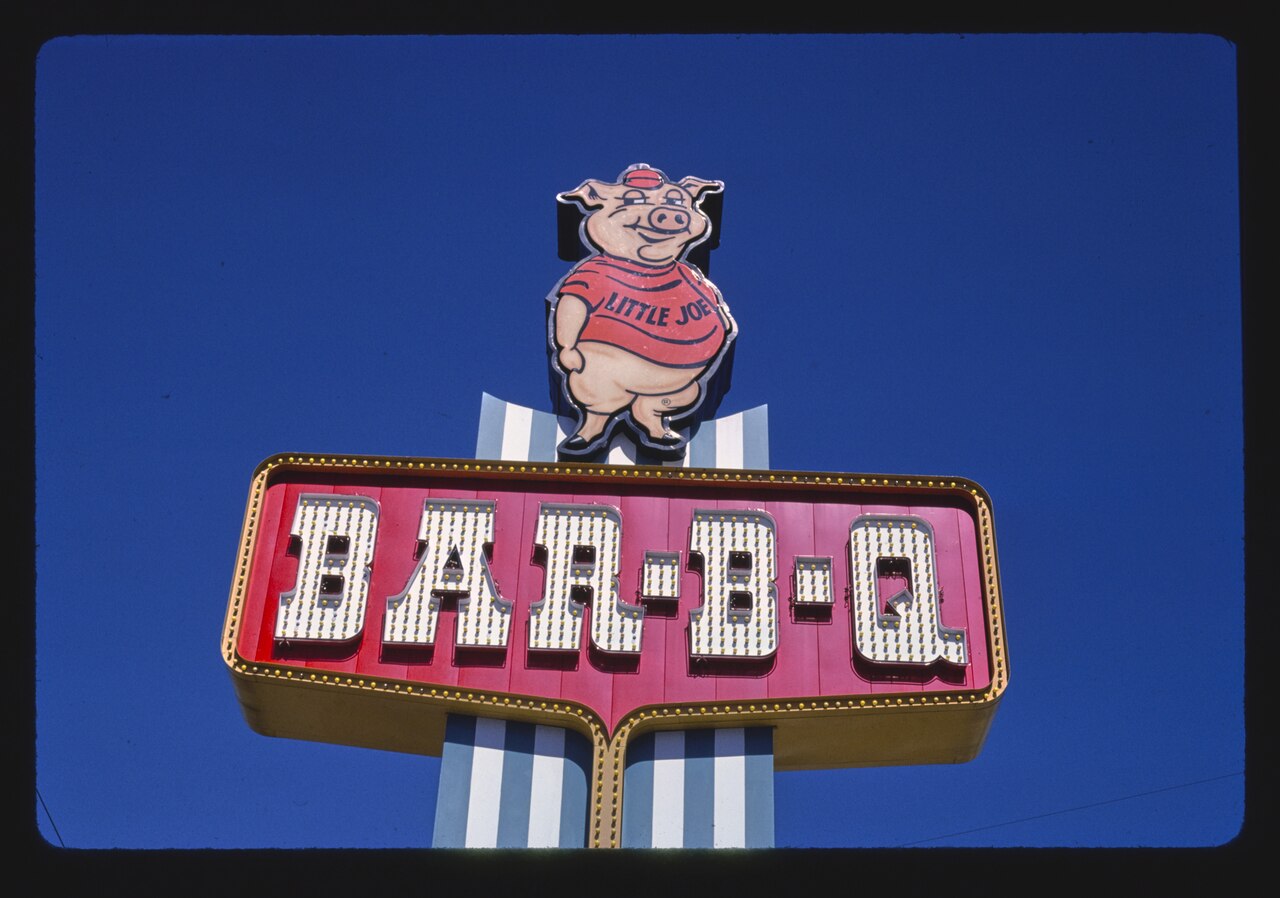 The Bessinger's sign at West Columbia photographed side on, showing the striped pylon carrying the Little Joe pig.
