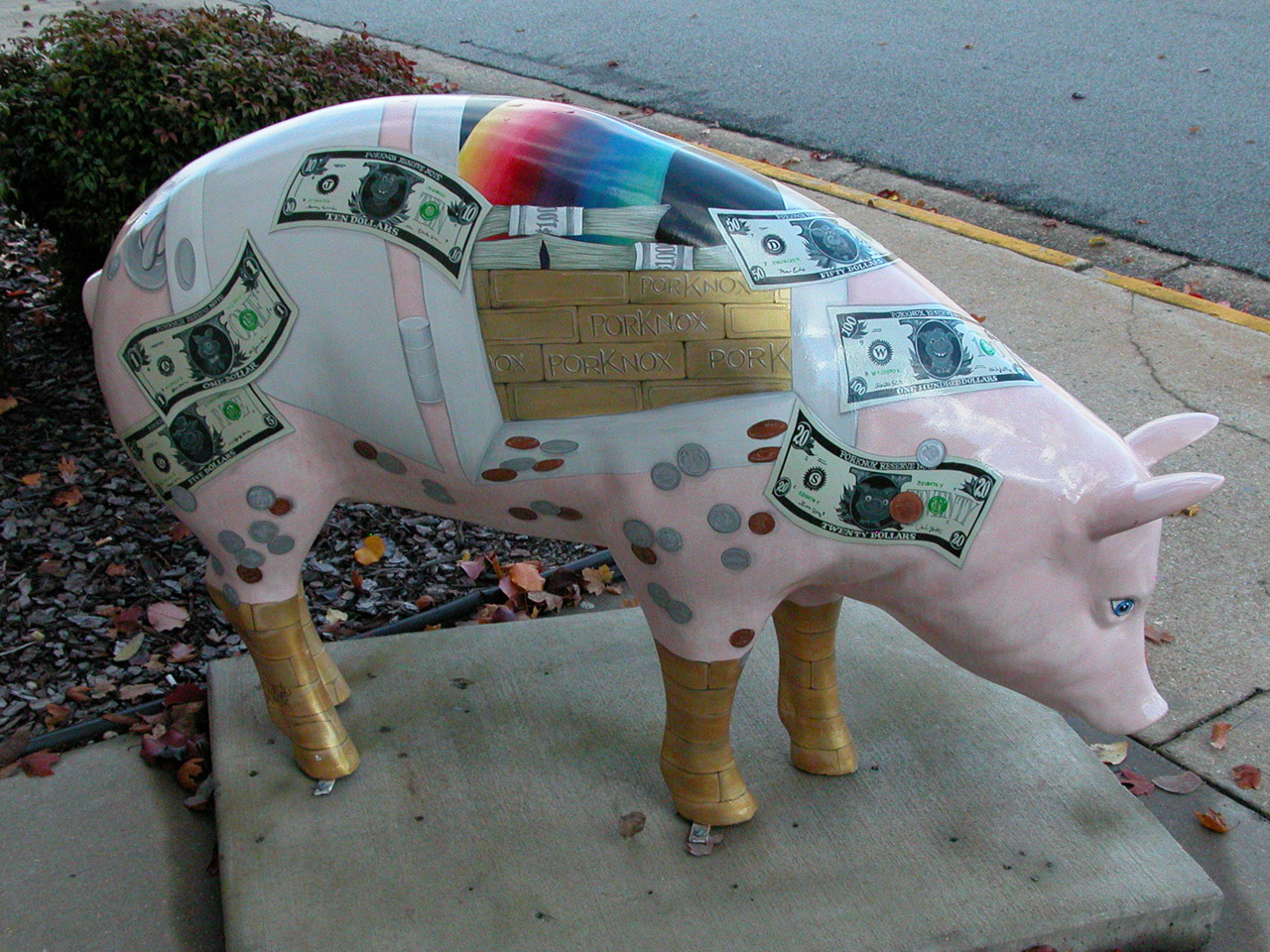 Pork Knox: a pig sculpture painted with banknotes and coins all over it, a bar chart along the back and gold trotters.