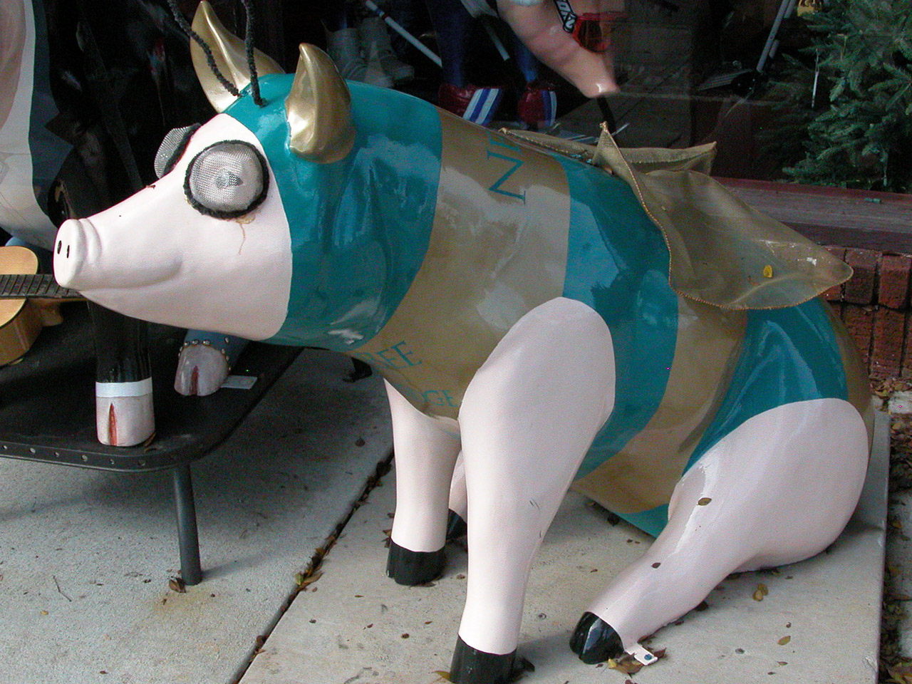 Newbee: a pig sculpture banded in teal and gold with gold antennae and a gauzy wing laid over its back.