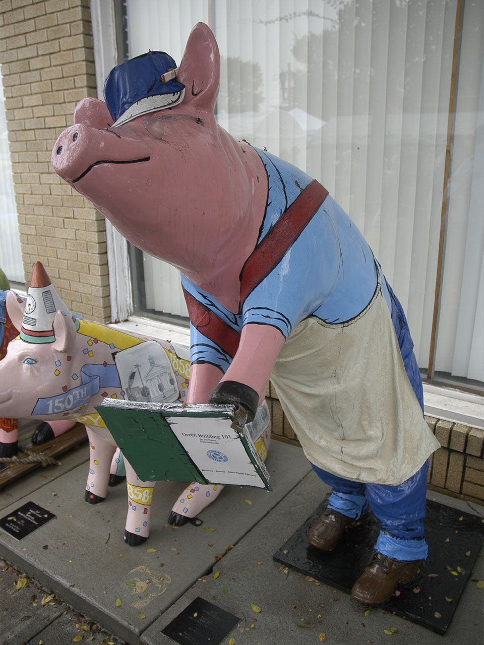 A painted pig sculpture standing on a street in uptown Lexington, North Carolina.