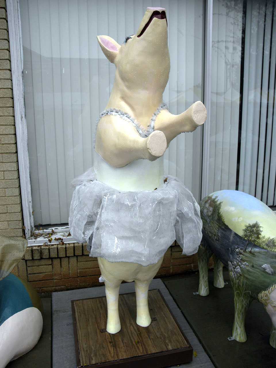 A painted pig sculpture standing on a street in uptown Lexington, North Carolina.