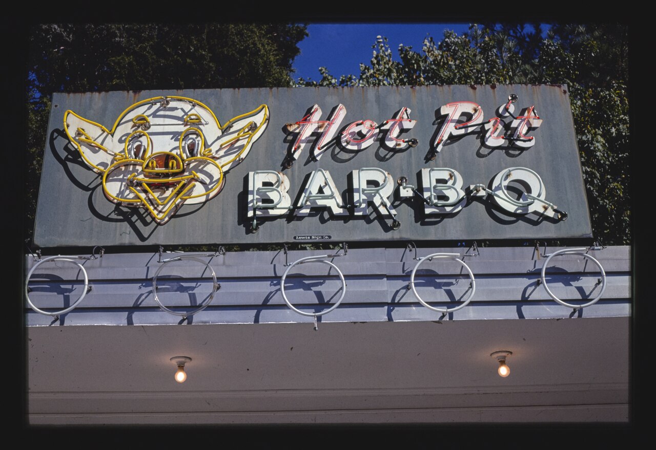 A plain rectangular sign on a pole lettered BAR-B-Q with lamps around the border. Brownsville, Tennessee, 1979.