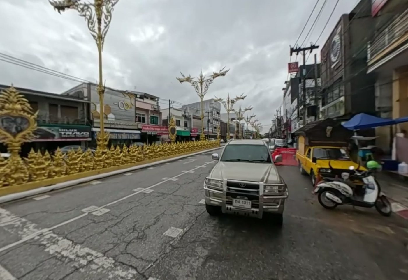 Avenue of golden Lanna-style lamp posts and shops leading from the roundabout