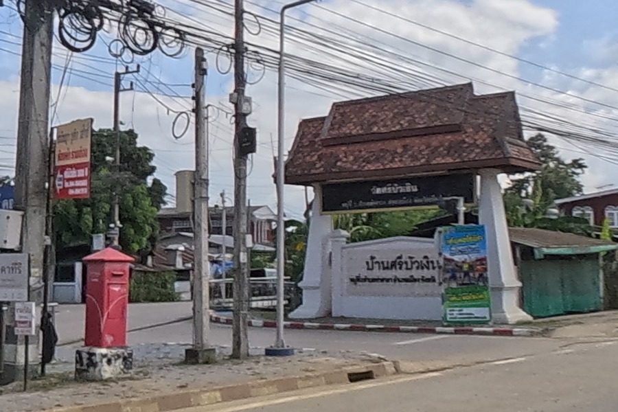 Tiled-roof gateway of บ้านศรีบัวเงิน beside a red post box