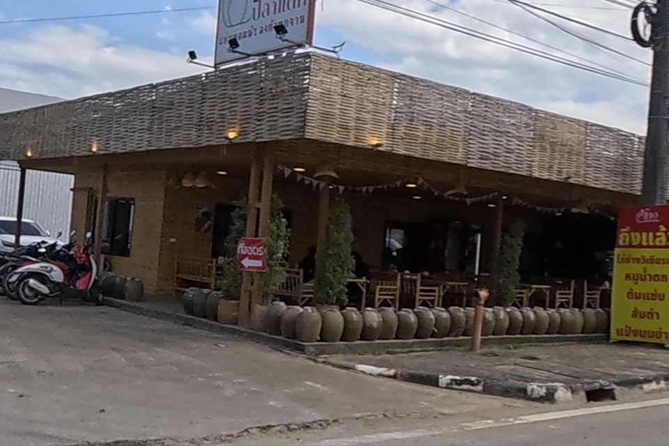 Woven-bamboo restaurant front lined with clay jars