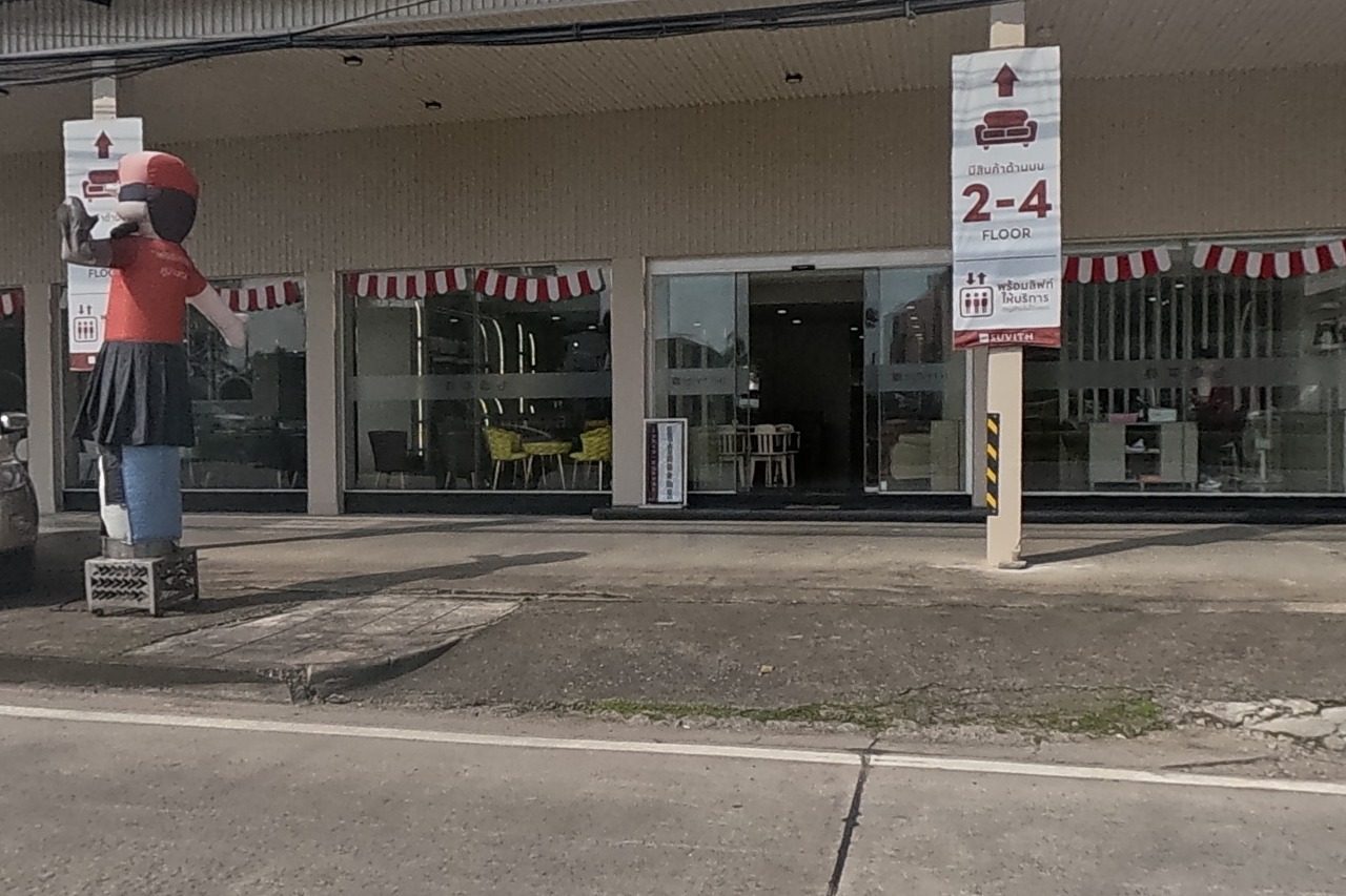 Suwit Furniture Baanma's full frontage is clearly signed, with a pickup truck and a mascot figure out front.