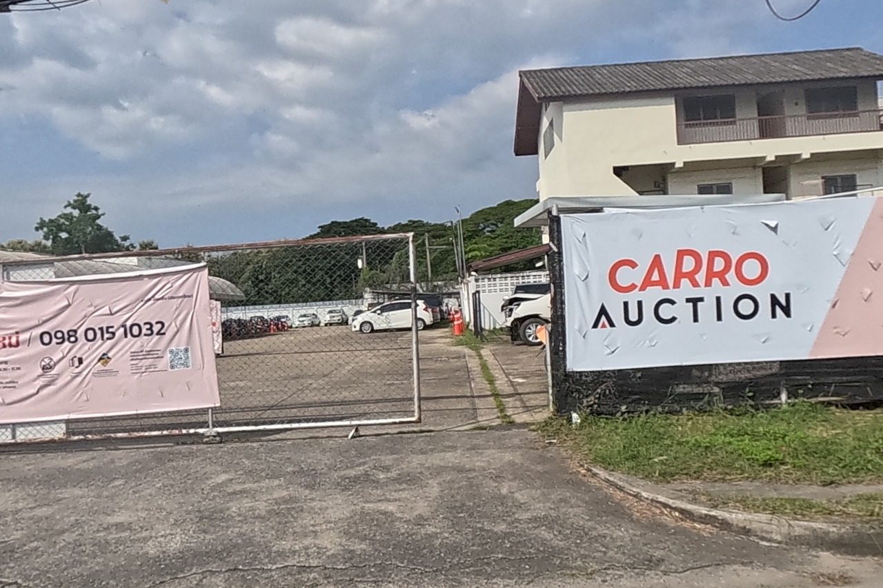 The CARRO Auction gate is fully signed with its phone number and an auction schedule.