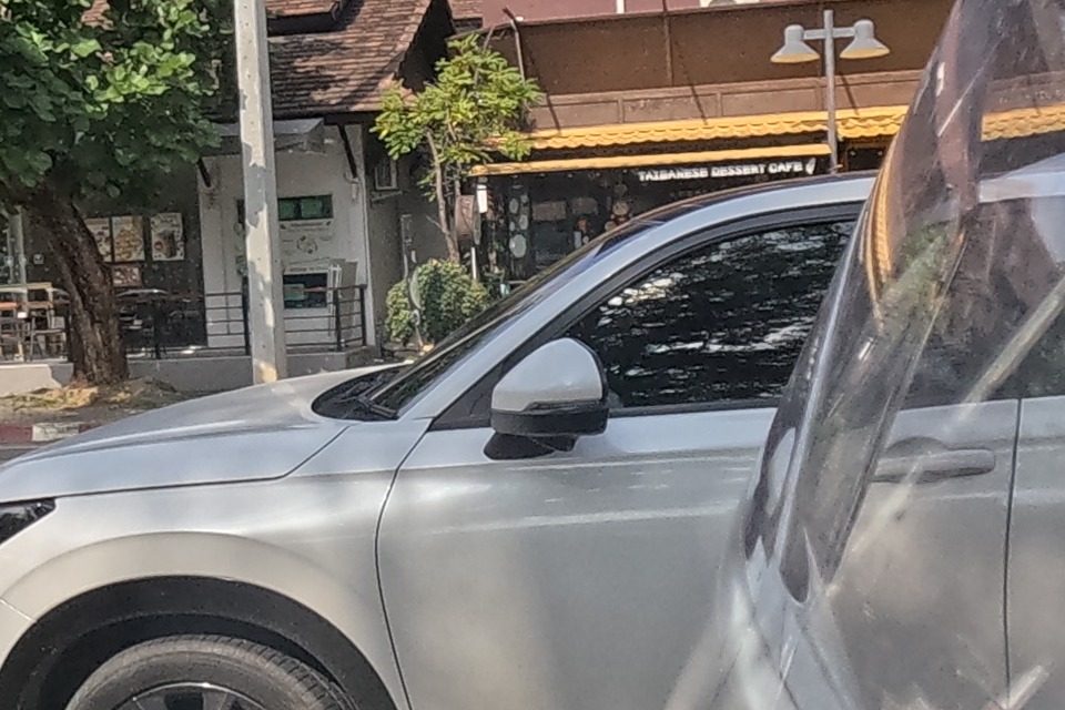 A Taiwanese dessert cafe sits among traditional wooden buildings with a 'For Lease' sign on a shophouse further along; a white SUV is parked at the curb.