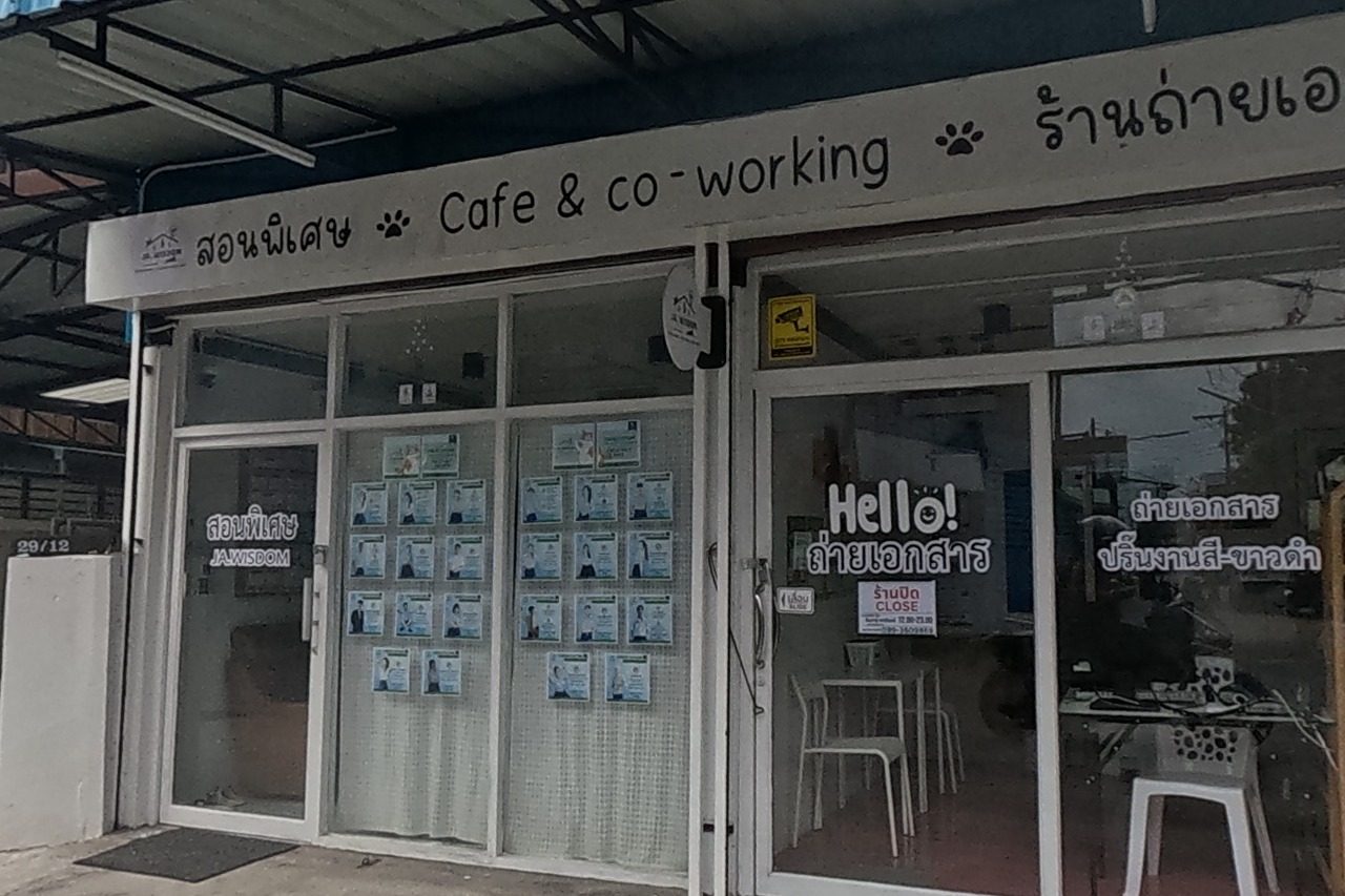 A shopfront combines a tutoring/cafe-and-coworking space (posters for 'JA WISDOM' classes in the window) with a photocopy shop next door advertising colour and black-and-white printing.