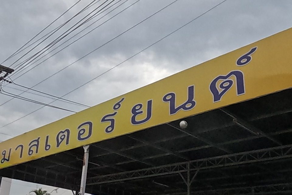 Master Yont used-car lot under a long yellow-roofed carport: 'ซื้อ-ขาย แลกเปลี่ยน รถยนต์ทุกชนิด' (buy-sell-trade all vehicle types), phone 081-7838388, many cars for sale in rows.