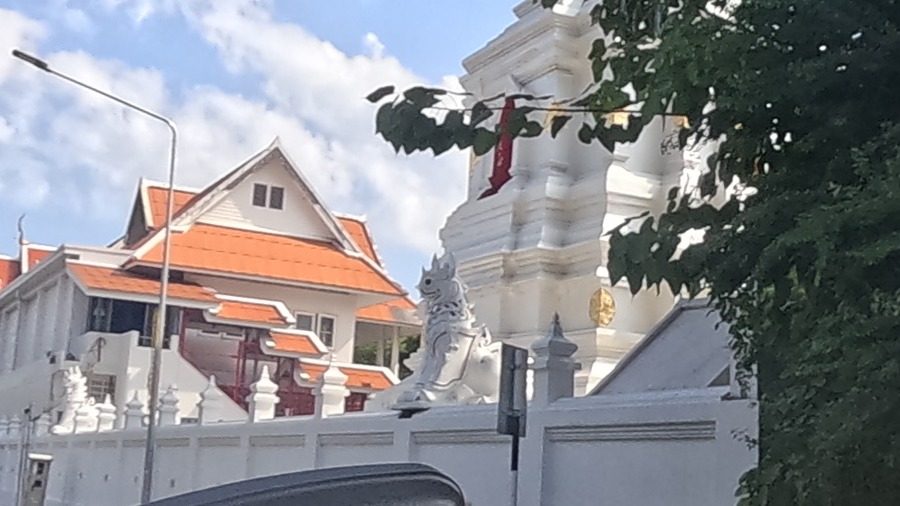 Wat Chai Sri Phoon gate with guardian lion and red flag