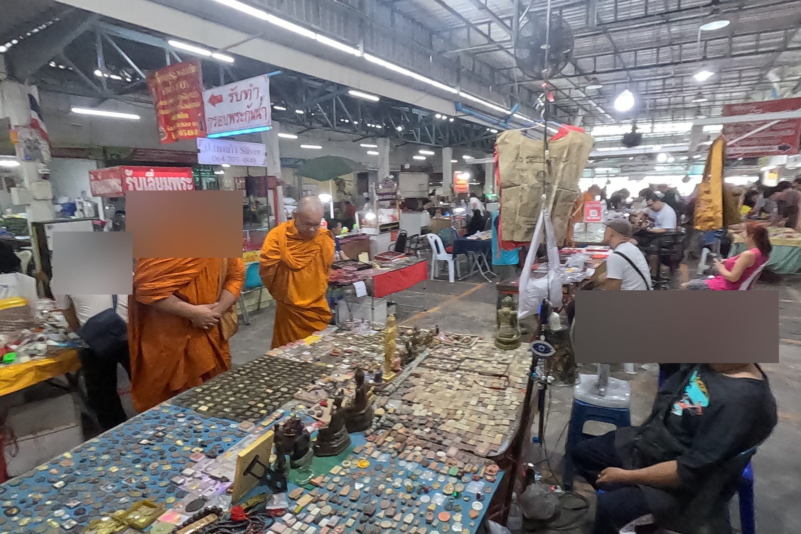 Monks browse a long amulet table