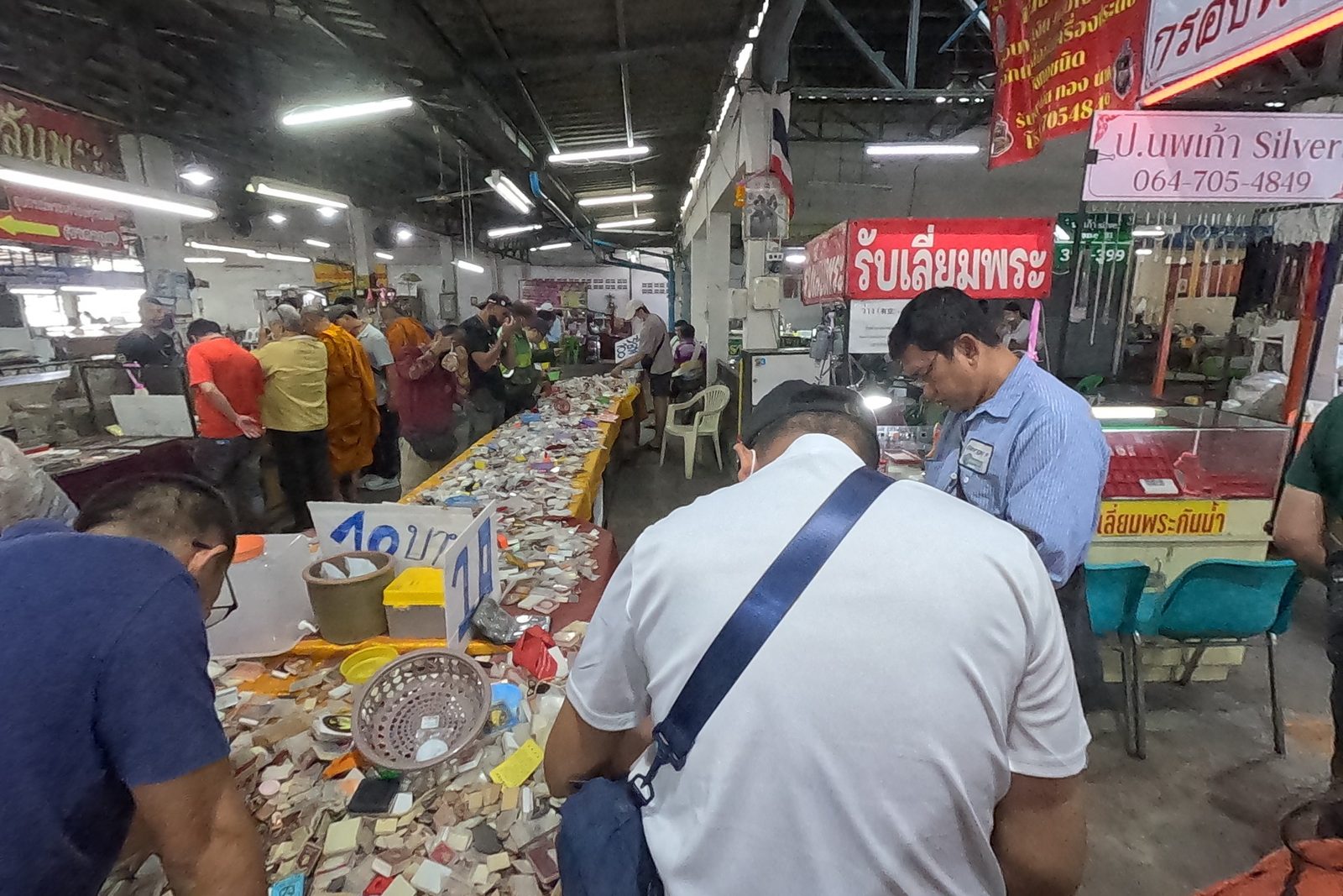 Monks and buyers at the ten-baht pile table