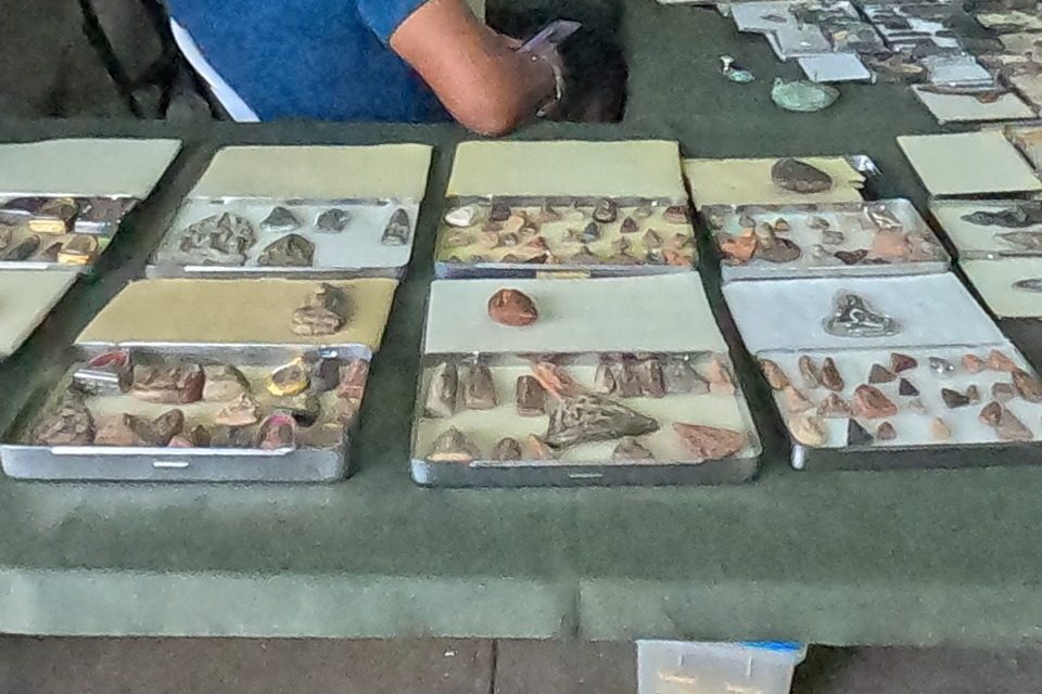Tins of clay votive tablets on a green table