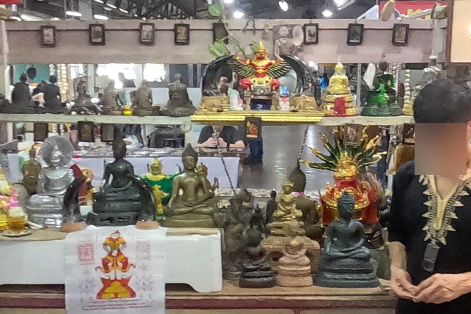 A Garuda and Buddha images on a stall shelf