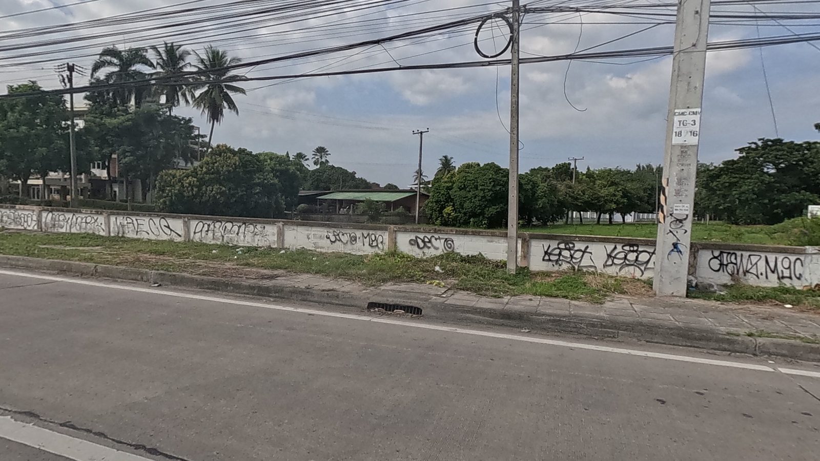 long wall covered in black spray tags
