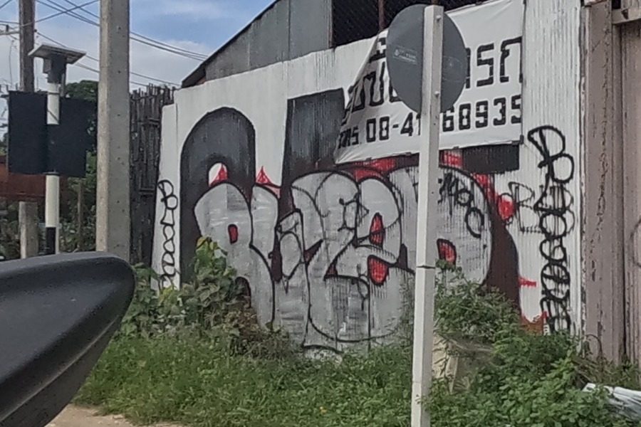 Black tag cluster with a heart on a derelict shophouse wall