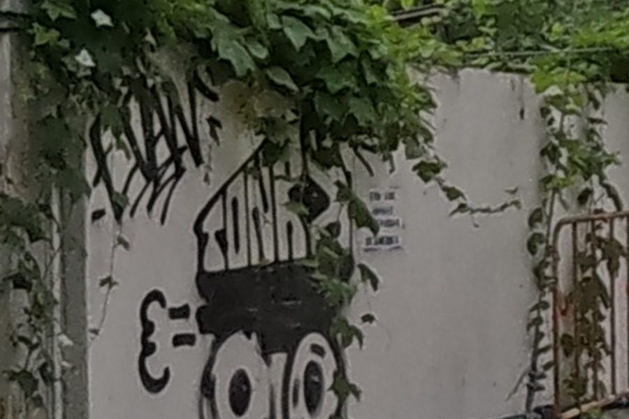 Stencil-style robot/tank character with gear wheels on a white wall