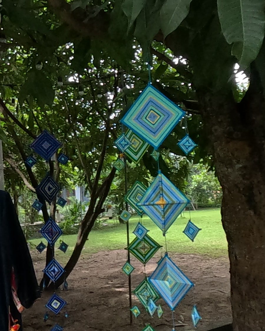 Blue yarn God's-eyes hung in a tree — Chamcha Market, San Kamphaeng
