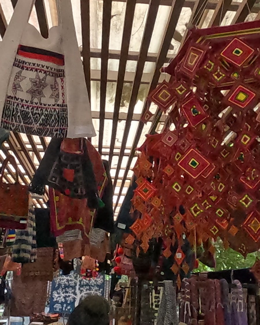 A cloud of red God's-eyes under the pergola — Chamcha Market, San Kamphaeng
