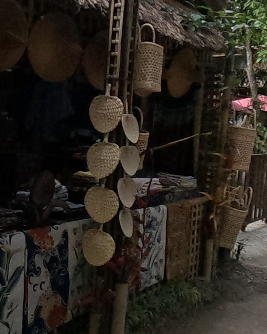 Palm-leaf fans hung in a column — Chamcha Market, San Kamphaeng