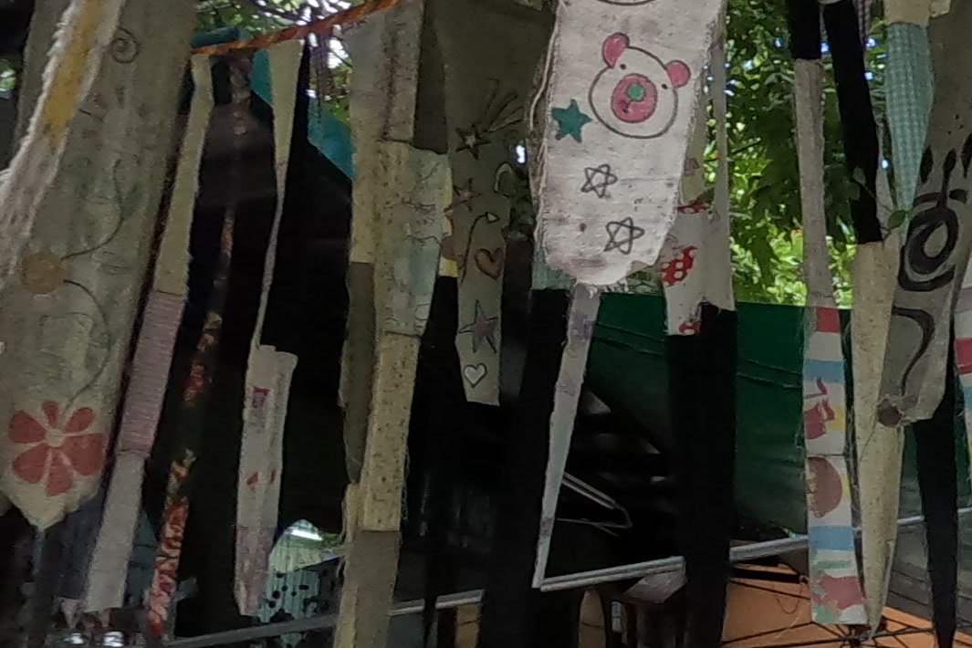Painted cloth strips with a pig face — Chamcha Market, San Kamphaeng