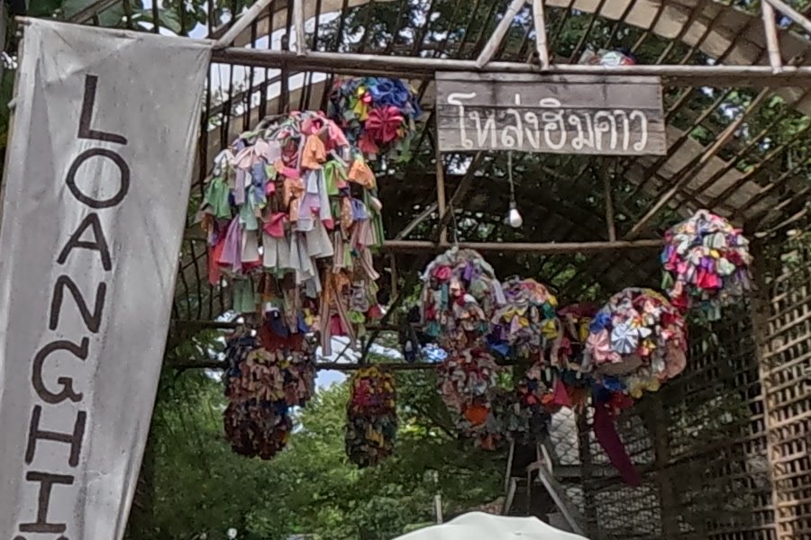 Cloth pom-poms under the Loanghimkao arch — Chamcha Market, San Kamphaeng
