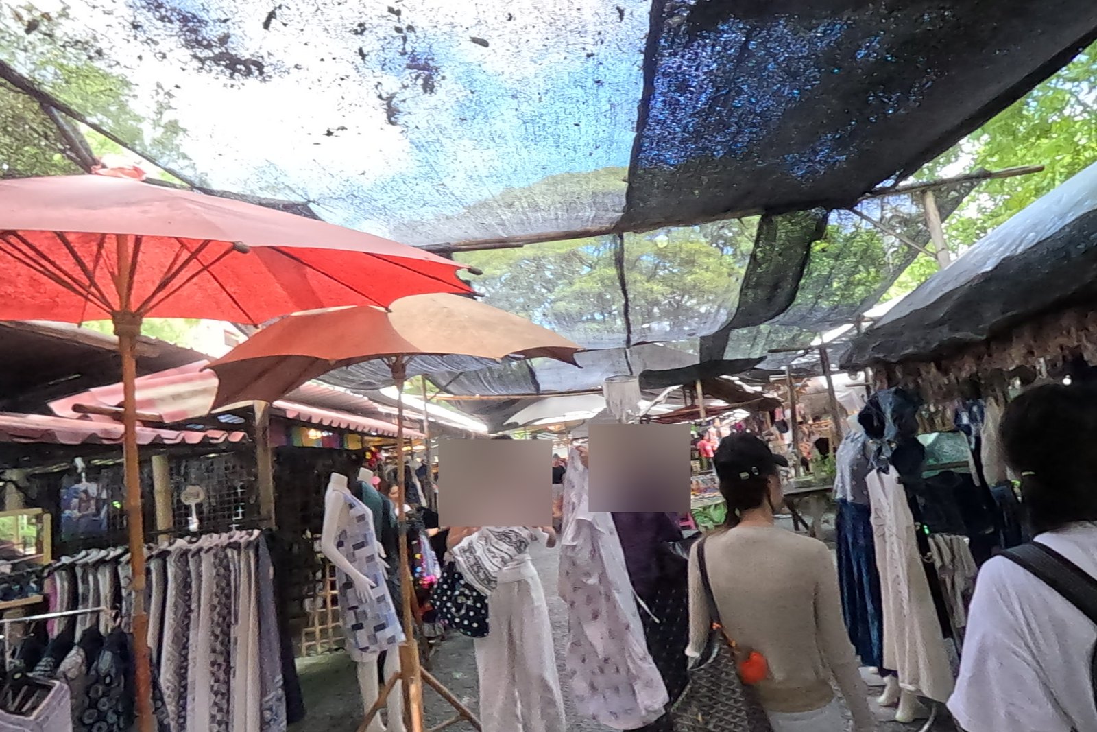Red paper umbrellas over the clothes lane — Chamcha Market, San Kamphaeng
