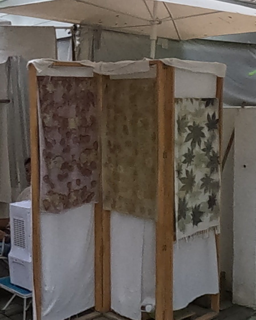 Leaf-printed scarves on a wooden rack — Chamcha Market, San Kamphaeng