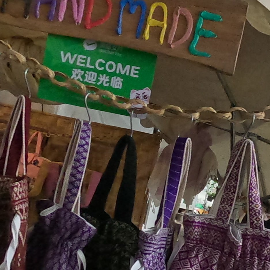 Woven totes under a HANDMADE sign — Chamcha Market, San Kamphaeng
