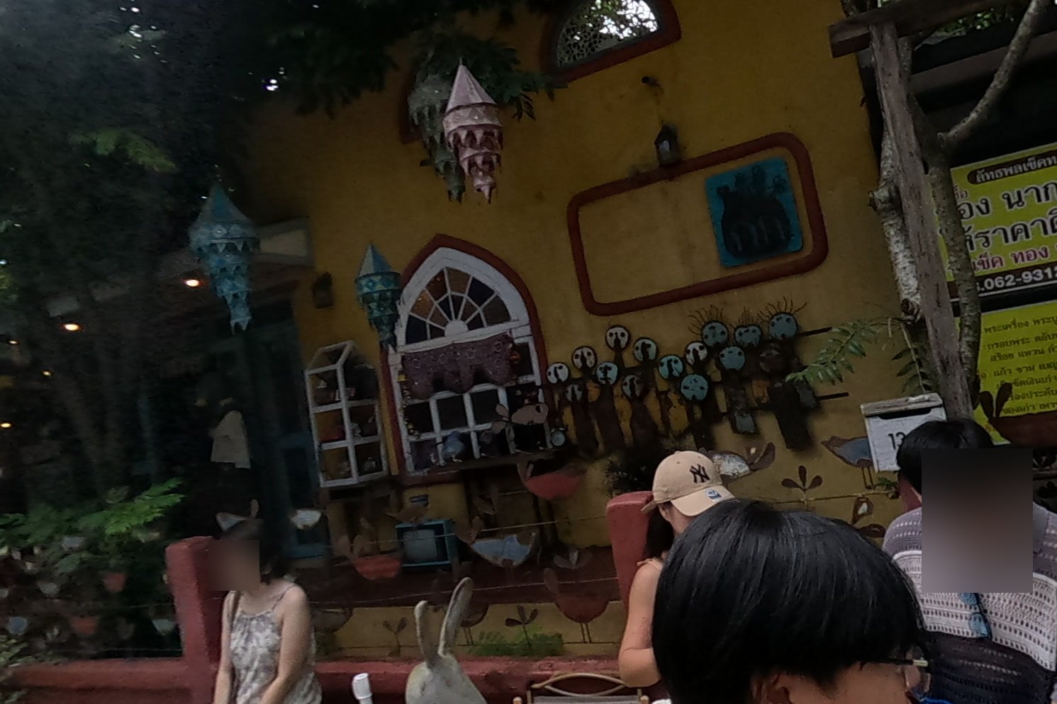The yellow folk-art house and its rabbit bench — Chamcha Market, San Kamphaeng