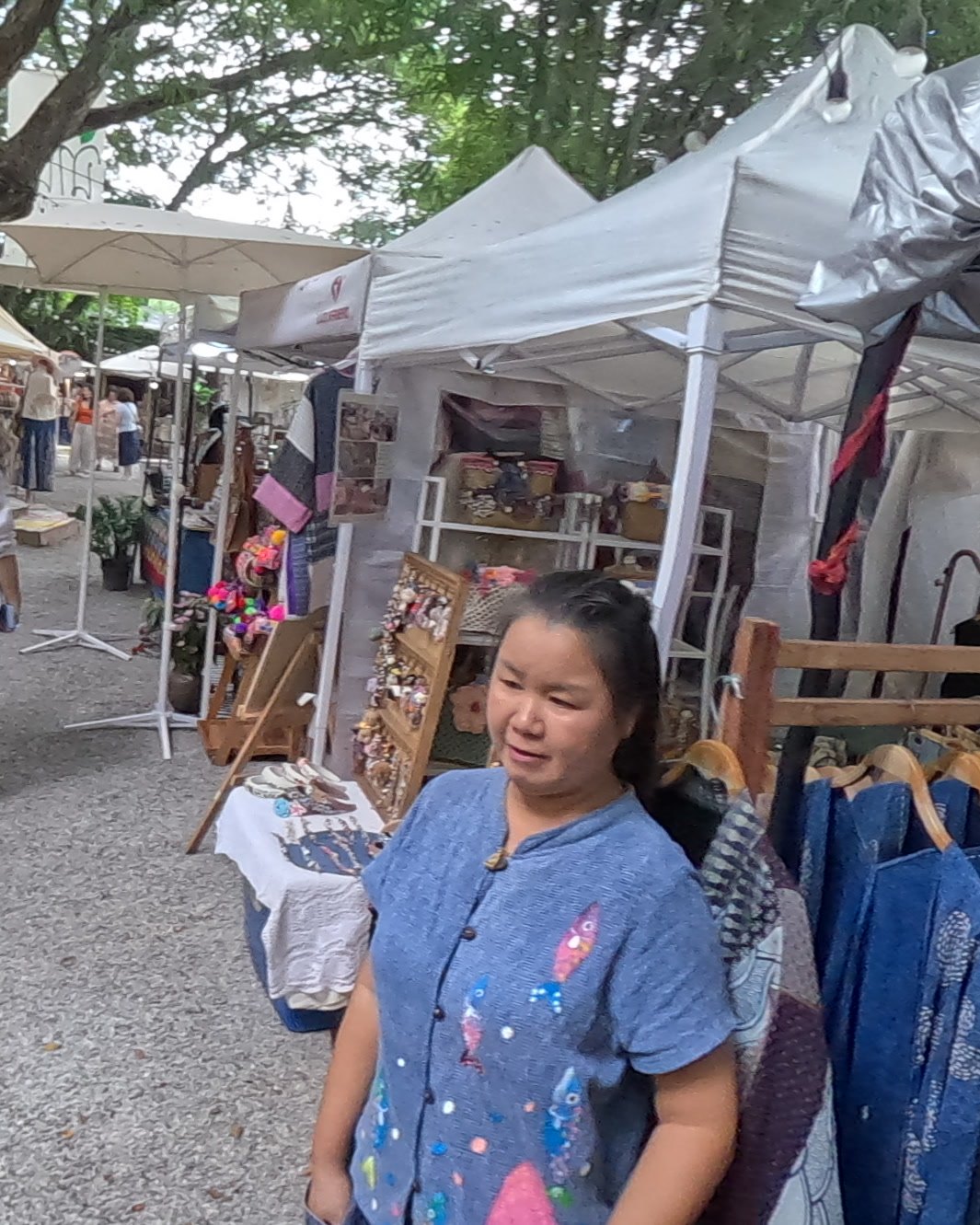 Stallholder in an embroidered blue top — Chamcha Market, San Kamphaeng