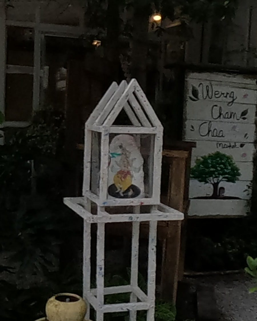 Small white glass-sided shrine on a stand — Chamcha Market, San Kamphaeng