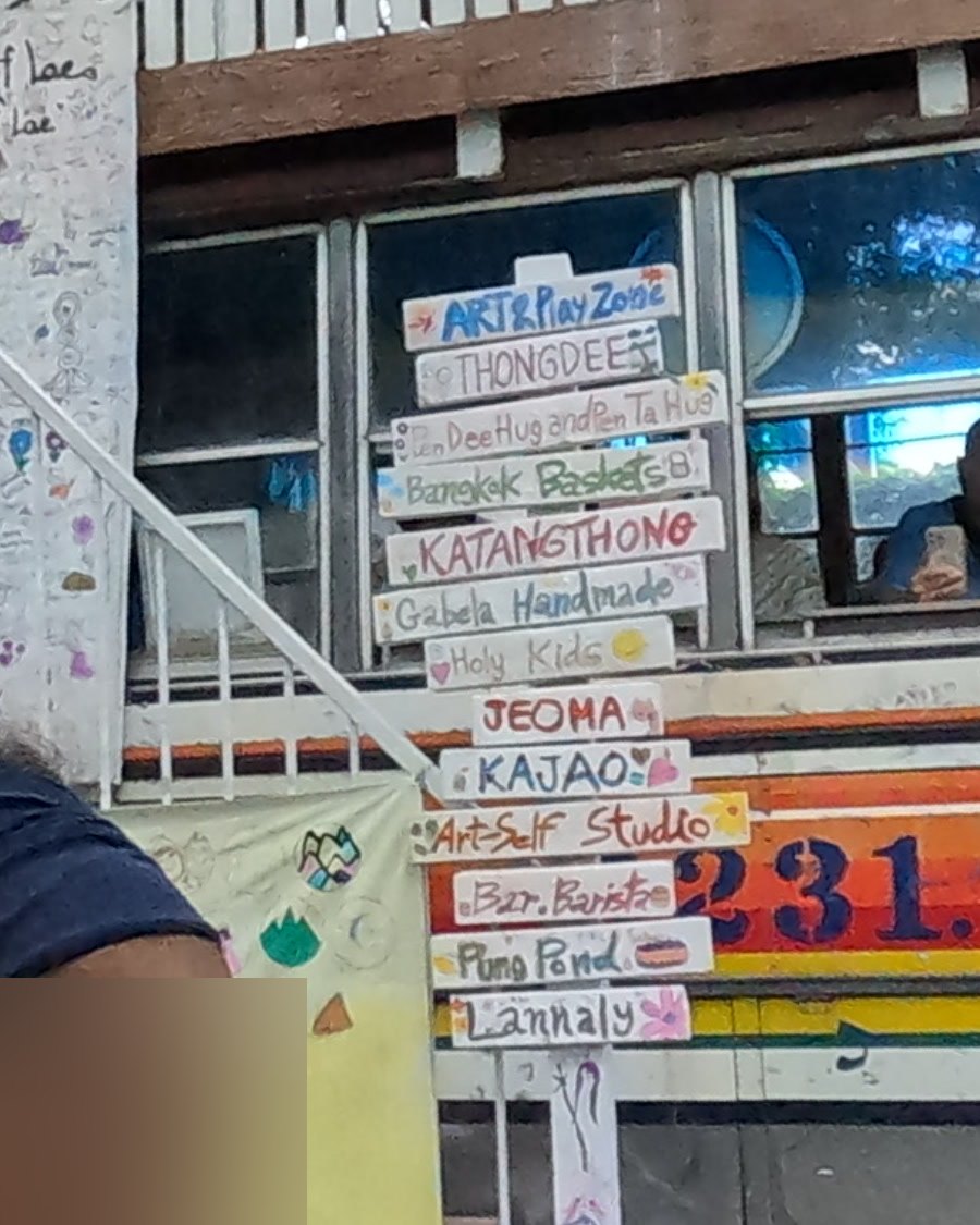 Painted shop directory on the bus stairs — Chamcha Market, San Kamphaeng
