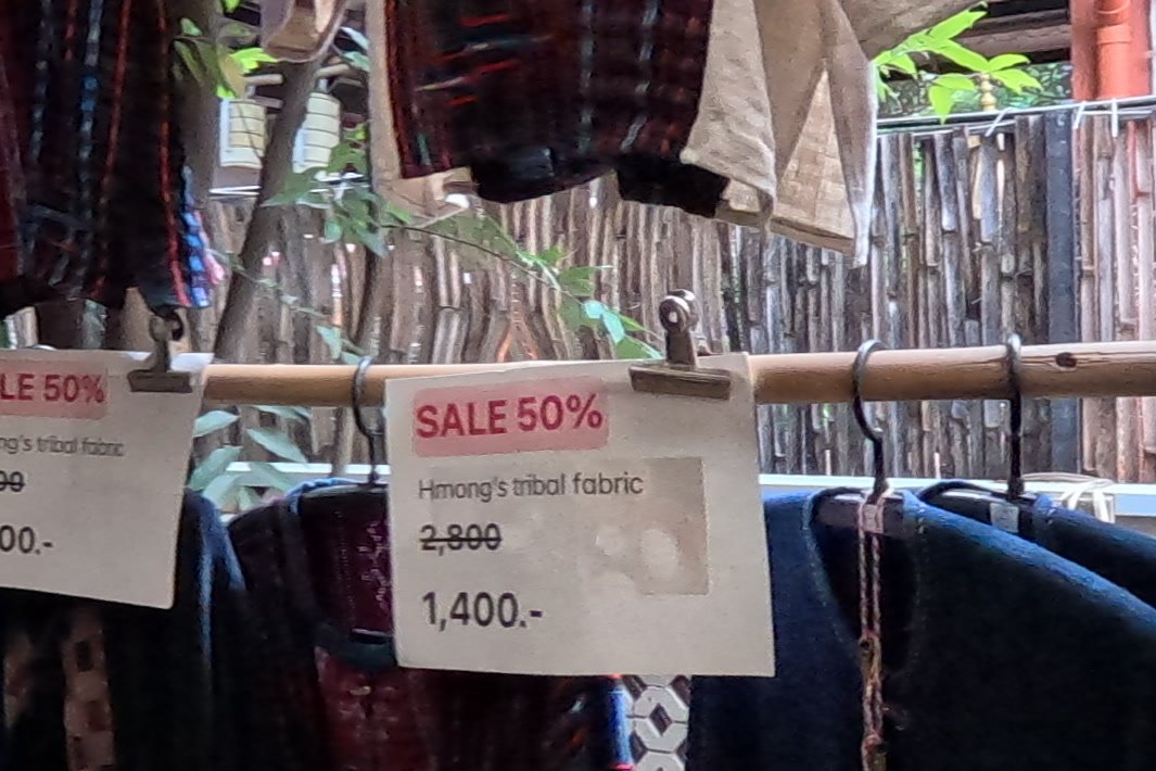 Sale tags on Hmong jackets: 2,800 now 1,400 — Chamcha Market, San Kamphaeng