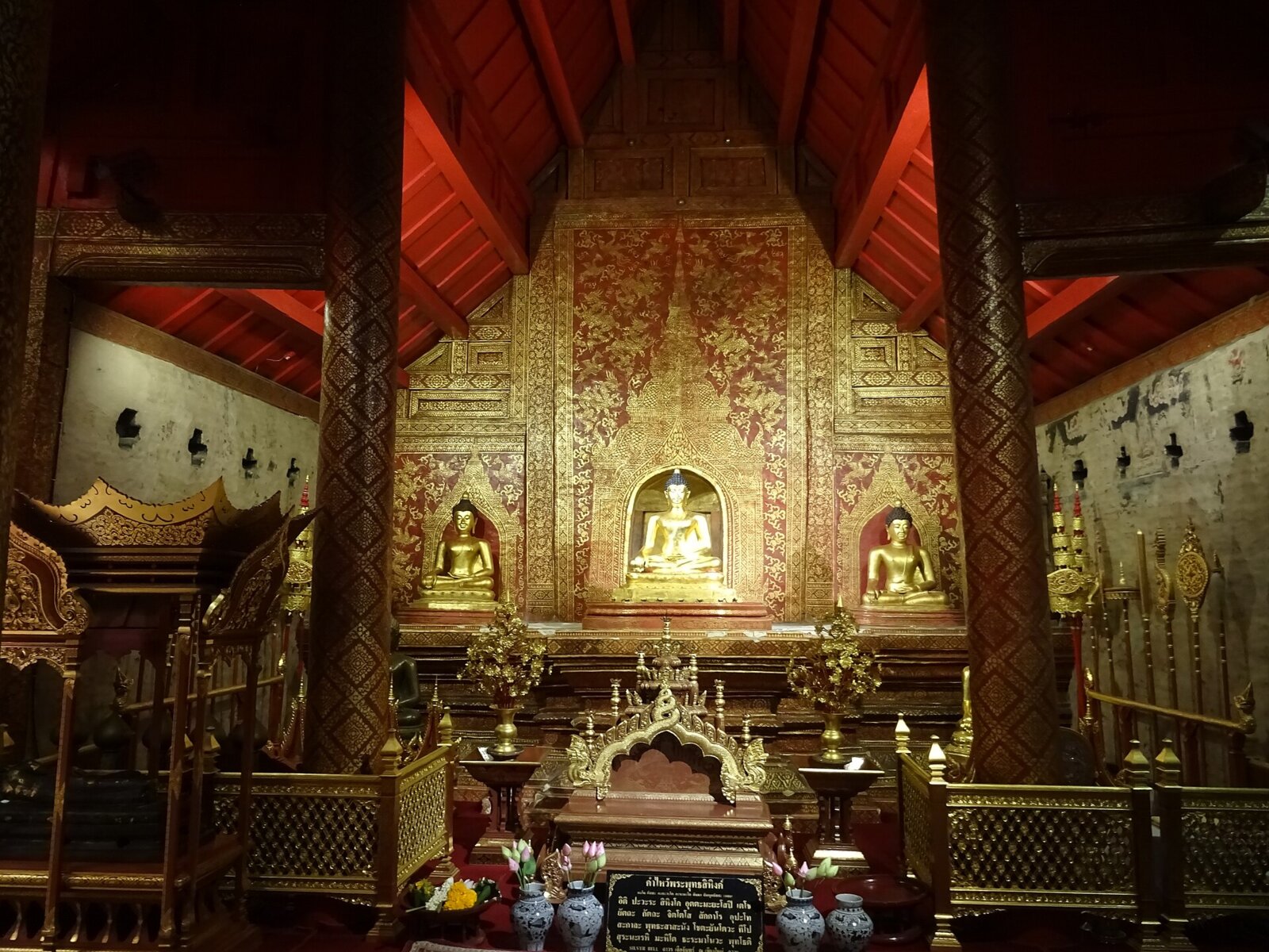 Interior of the Wihan Lai Kham, Wat Phra Singh, Chiang Mai: red-and-gold Lanna gilt work (lai kham) around the Phra Phuttha Sihing.