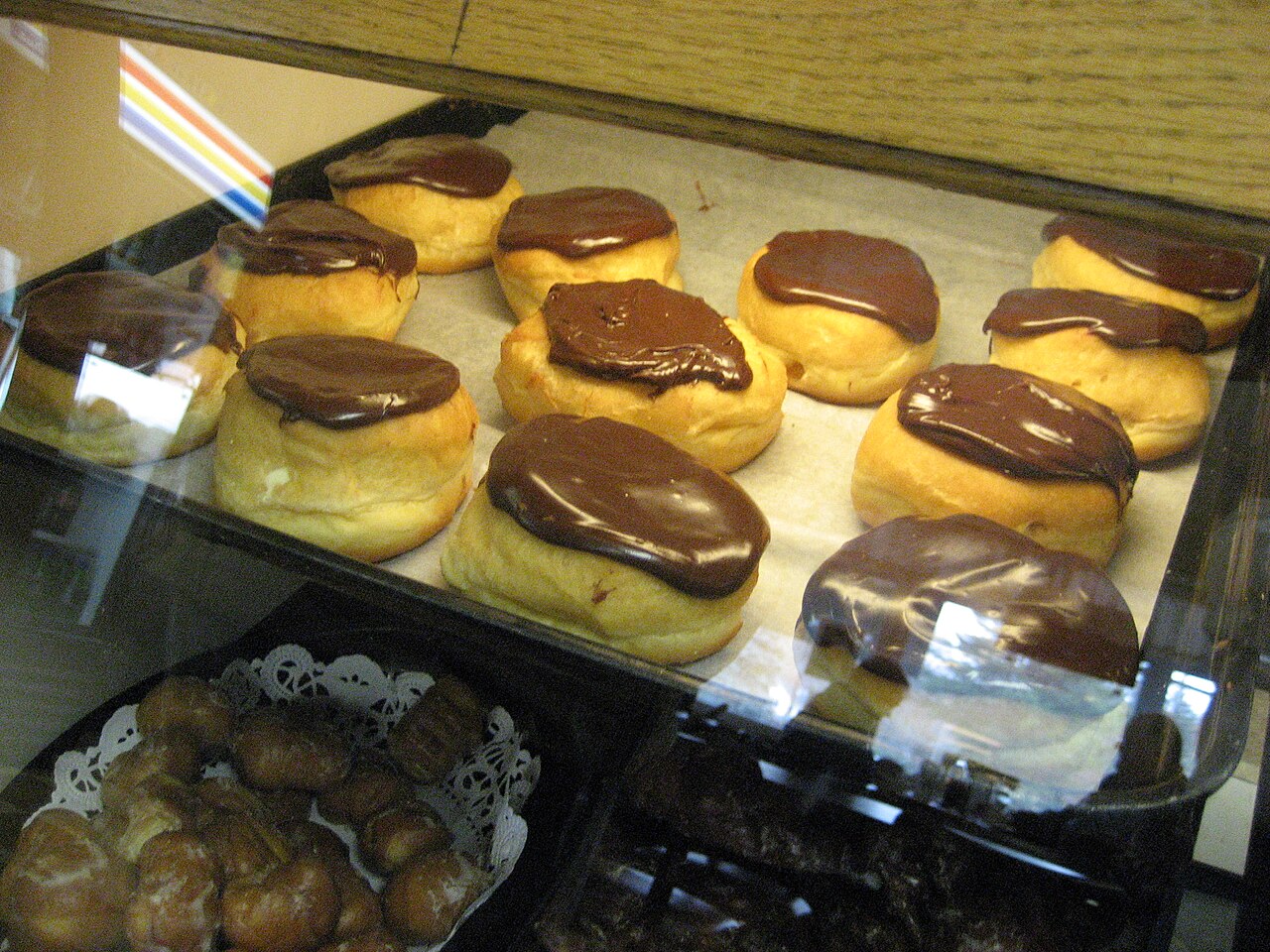Boston cream doughnuts in display case.
