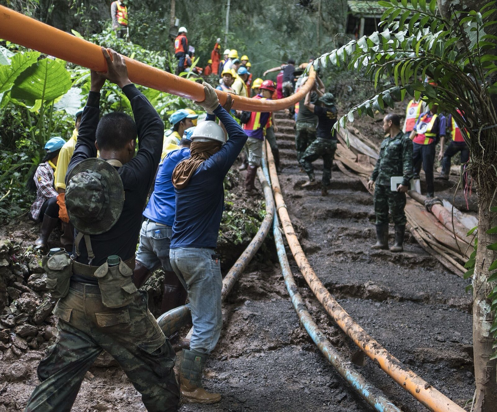 2 July 2018: Thai rescue workers carry pipe up to the cave for the pumps.